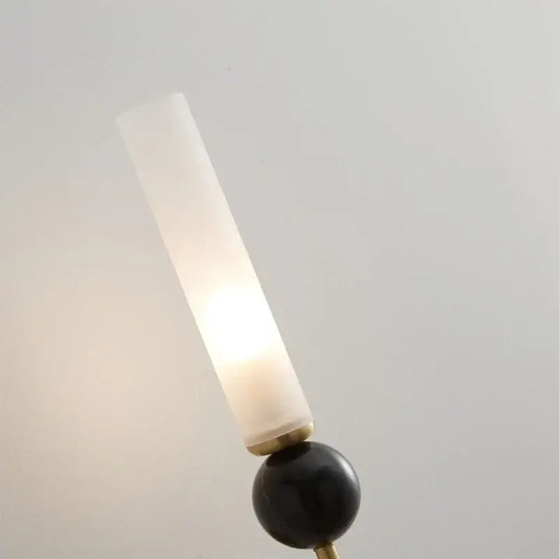 Modern gold and black wall lamp with a frosted glass shade and copper base for elegant living room decor