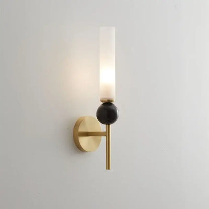 Modern gold and black wall lamp with copper base, frosted glass shade, and glossy black spherical accent for living room decor