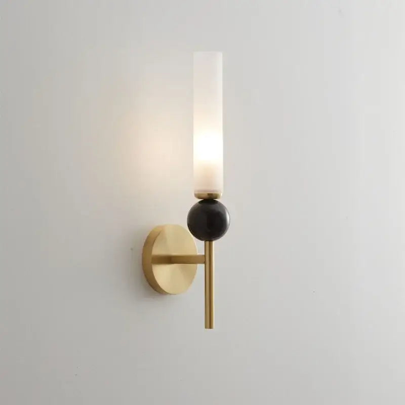 Modern gold and black wall lamp with copper base, frosted glass shade, and glossy black spherical accent for living room decor