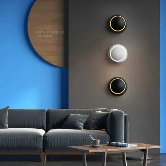 Three circular decorbites adjustable led crescent wall lights with gold rims and black and white illuminated surfaces