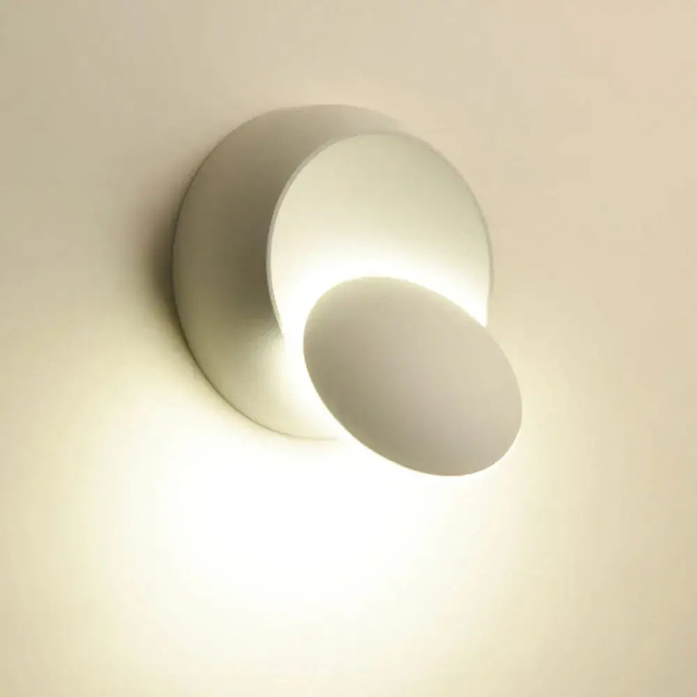 Modern gold black and white decorbites adjustable led crescent wall light above gray fabric sectional sofa with yellow pillow