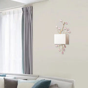 Modern gold branch wall sconce with white fabric shade and pink crystal accent for elegant bedroom lighting