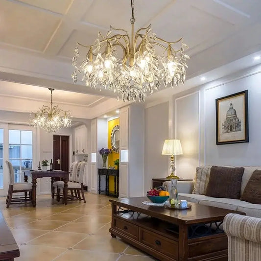 Modern gold decorbites crystal chandelier with crystal droplets on an ornate branching metal frame for living room use