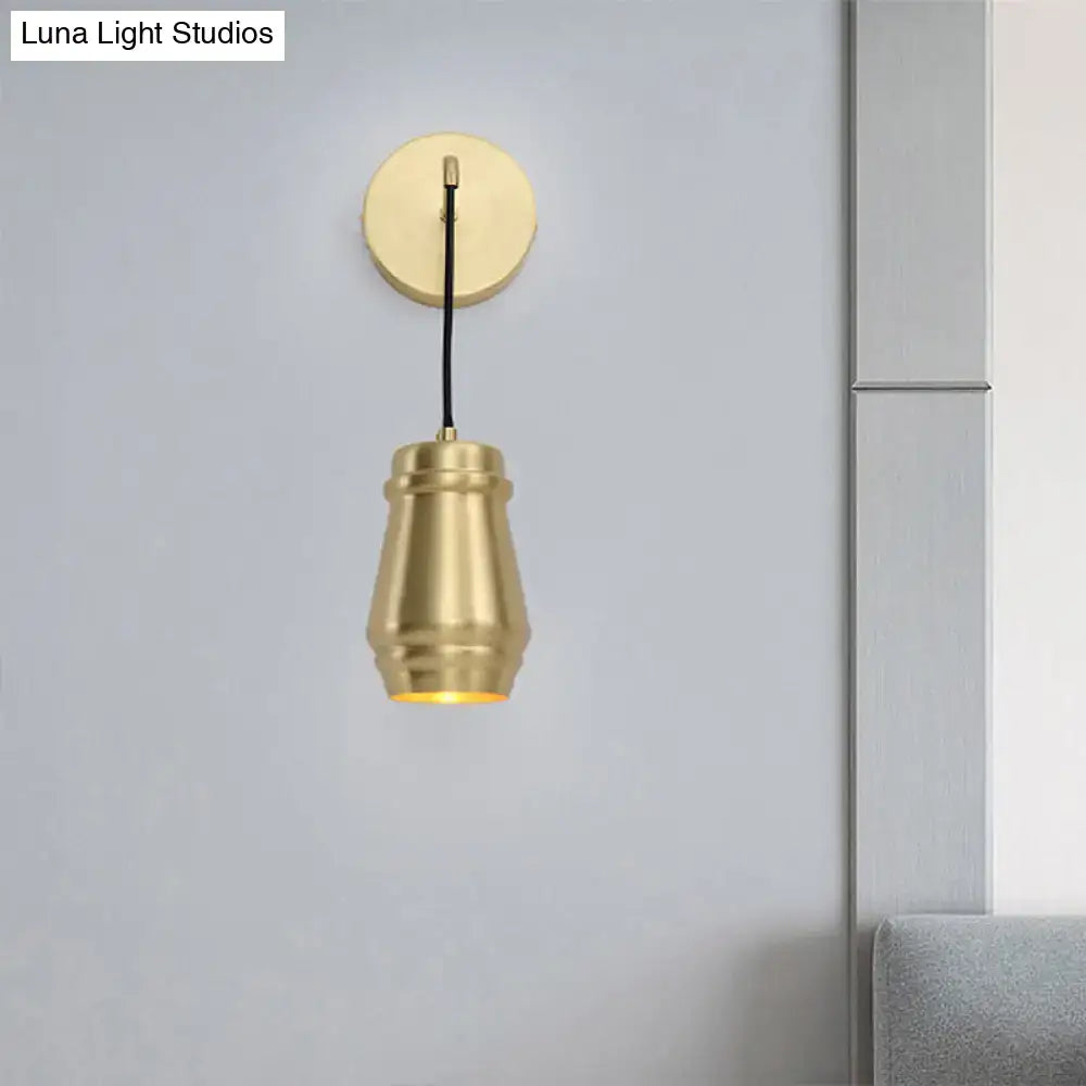Modern gold brass bedroom wall sconce with a brass-finished metal shade and cylindrical inch fixture design