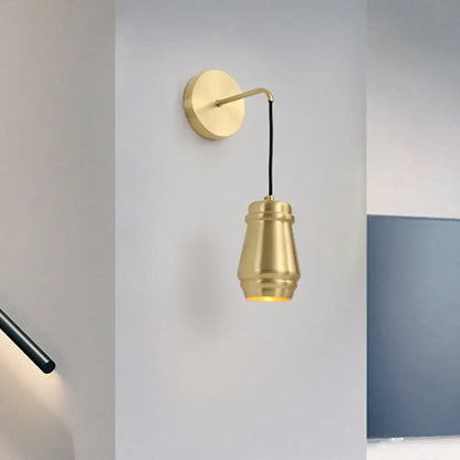 Modern gold brass bedroom wall sconce with metal shade and sleek curved arm inch fixture for stylish lighting