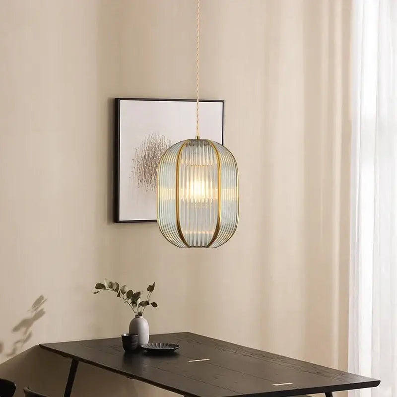 Modern gold brass glass restaurant light featuring a blue green translucent shade with slender metal ribs pendant decorbites brass glass
