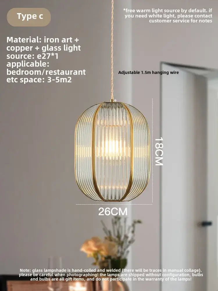 Modern gold brass glass restaurant light featuring a cylindrical glass shade with copper bars and warm ambient lighting