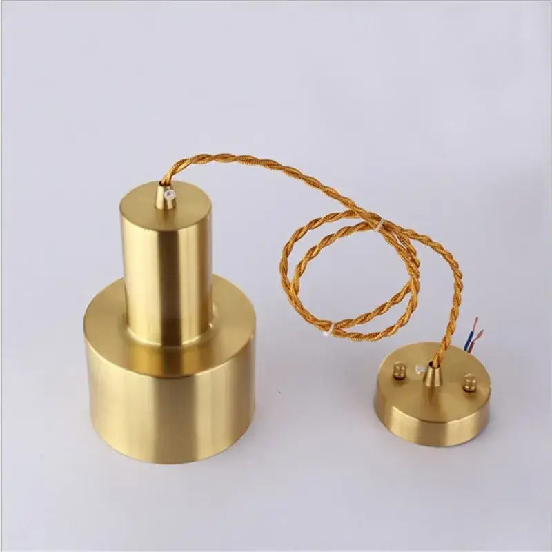 Modern gold brass trumpet pendant light with cylindrical brass finish, twisted gold cable, and matching circular base