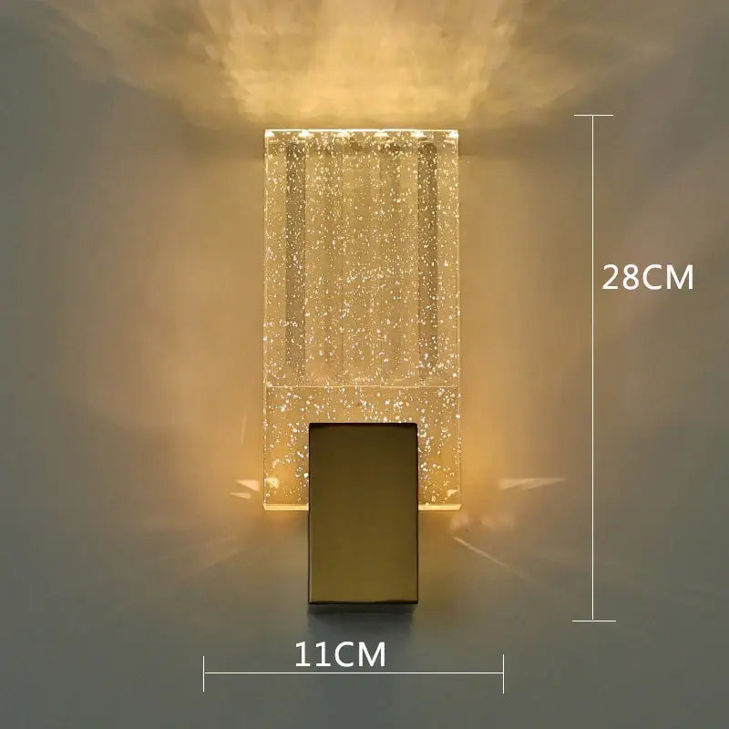 A modern gold bubble crystal led wall sconce with translucent acrylic body and warm ambient light for living rooms