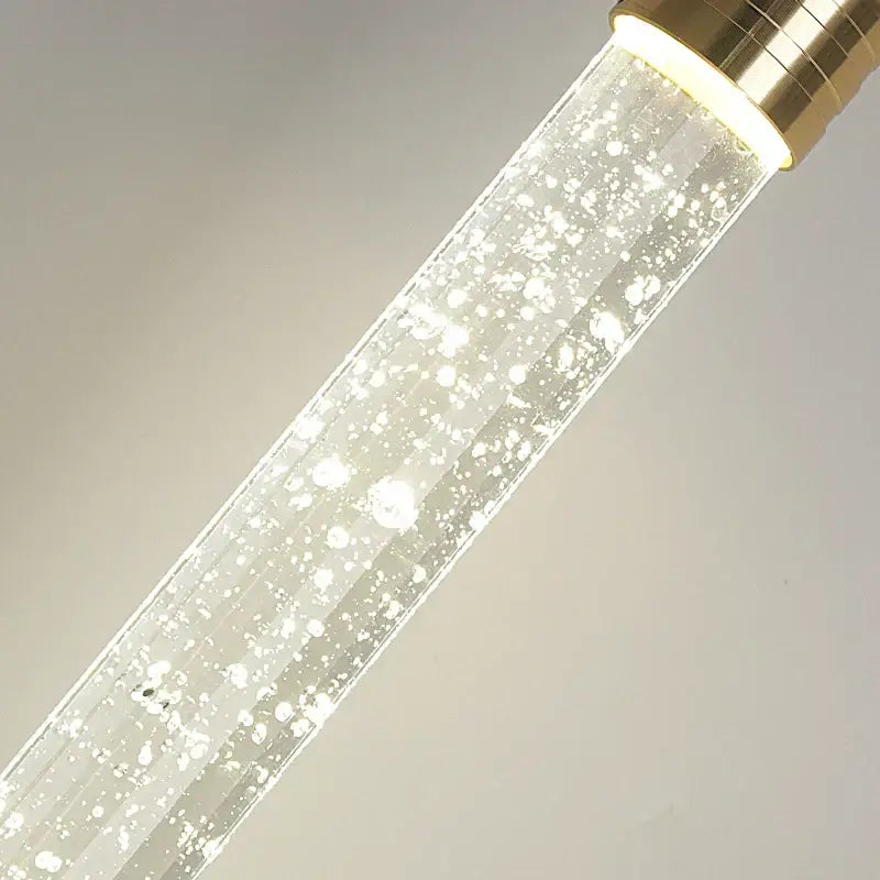 Modern gold bubble crystal pendant light featuring a clear glass tube with gold-toned cap and internal floating bubbles