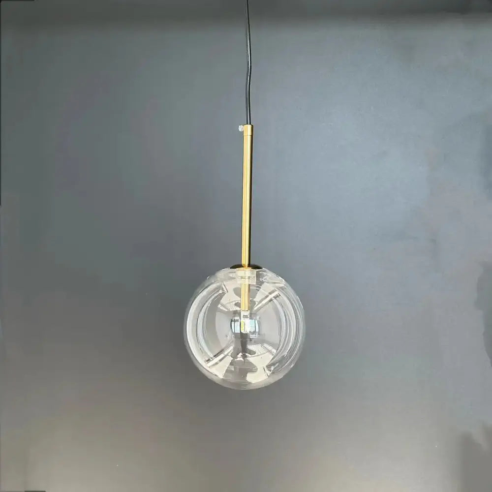 Modern gold bubble glass ball pendant light featuring a clear glass globe and slender gold-toned rod for kitchen decorbites bubble glass