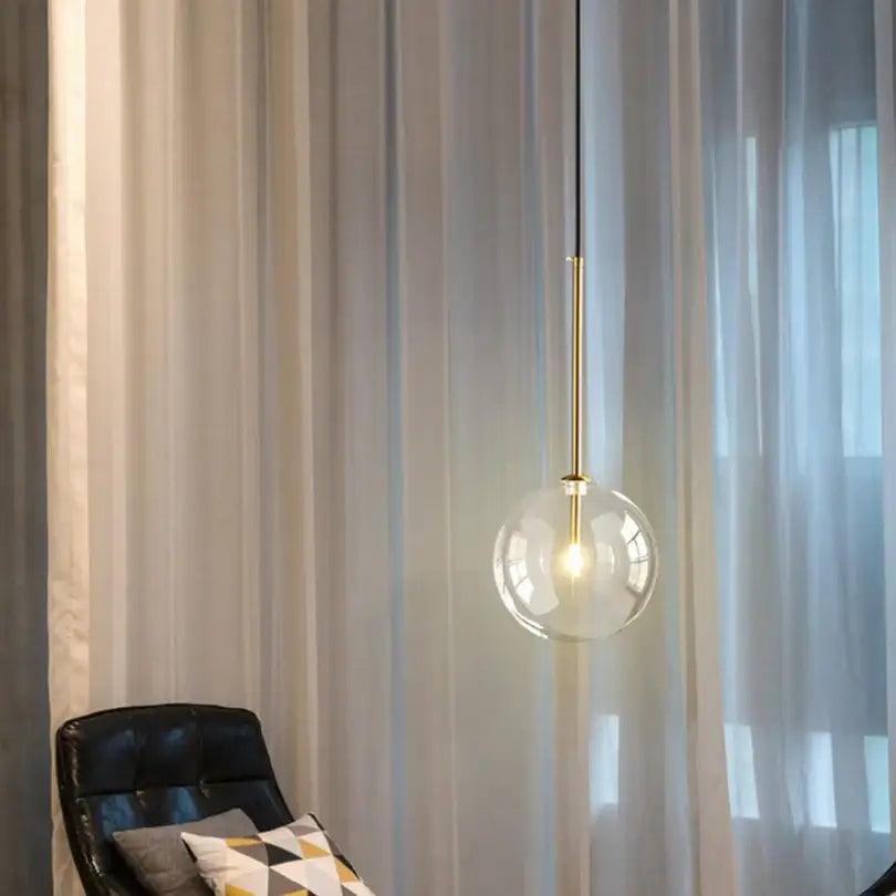 A modern gold bubble glass ball pendant light with clear glass globe and brass rod for kitchen decorbites bubble glass