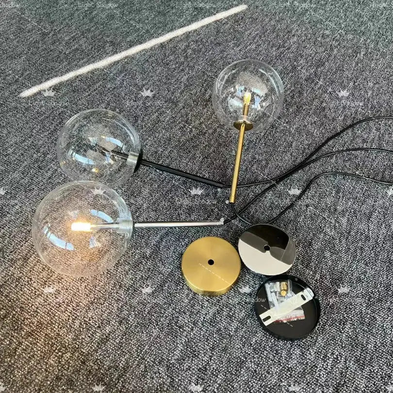 Modern gold bubble glass ball pendant light with brass and black metal accents featuring clear glass globe bulbs