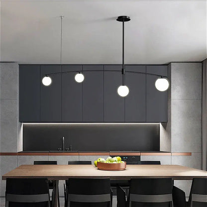 Modern black pendant light with three white spherical bulbs and curved arm from decorbites bubble iron chandelier collection