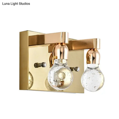 Modern gold bulb shaped crystal wall sconce with clear glass bubble bulbs and brass accents for 110v-120v bedroom lighting