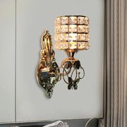 Modern gold butterfly wall light fixture with cylindrical crystal shade and ornate design for living room sconce