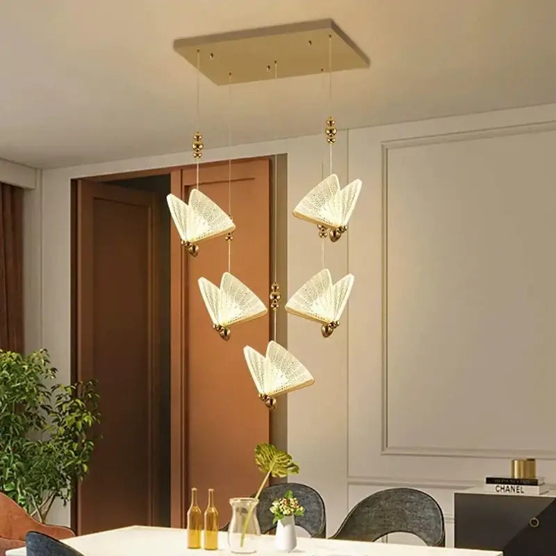 Modern gold butterfly led chandelier with five open-book-shaped crystal pendant lights and warm gold-toned decorbites butterfly led accents