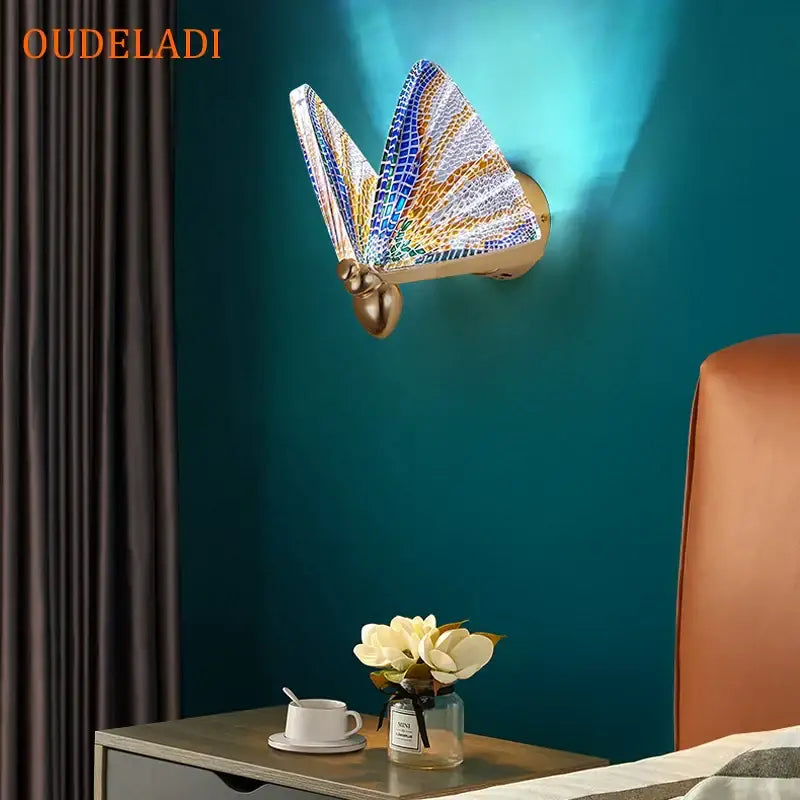 Modern gold butterfly wall lamp with blue gold and white mosaic wings for bedroom decor on teal wall by decorbites butterfly wall