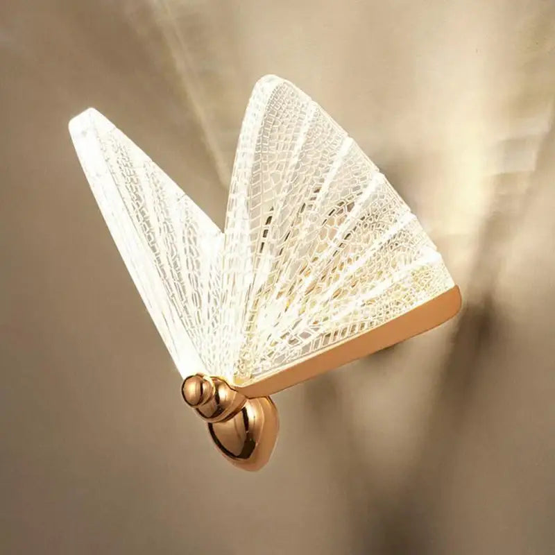 A delicate white butterfly wall lamp with gold-toned base and lace detailing for modern bedroom decorbites butterfly wall decor