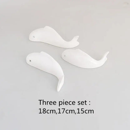 Set of three white ceramic whale figurines with glossy finish and metallic eyes complement decorbites carp fish wall pendant