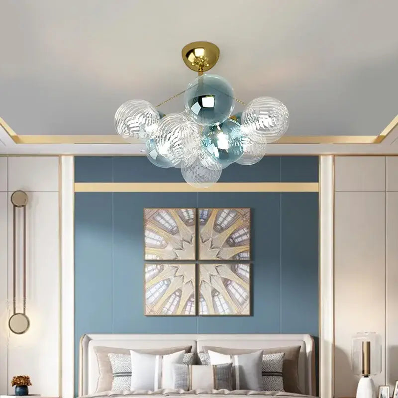 Modern gold cartoon bubble ball chandelier with gold ceiling mount and glass globes in white, blue, and teal for kids room