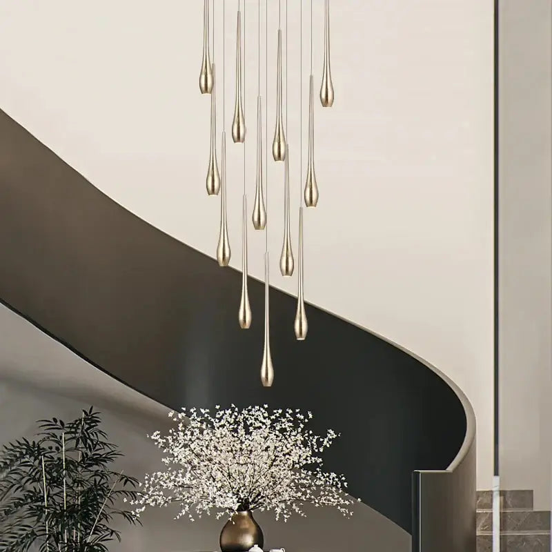 A modern gold-toned led ceiling chandelier with slender teardrop fixtures in a cascading design for living room use