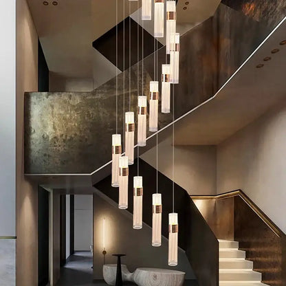 Modern gold cascading pendant light with cylindrical glass shades brass accents and adjustable height for dining room
