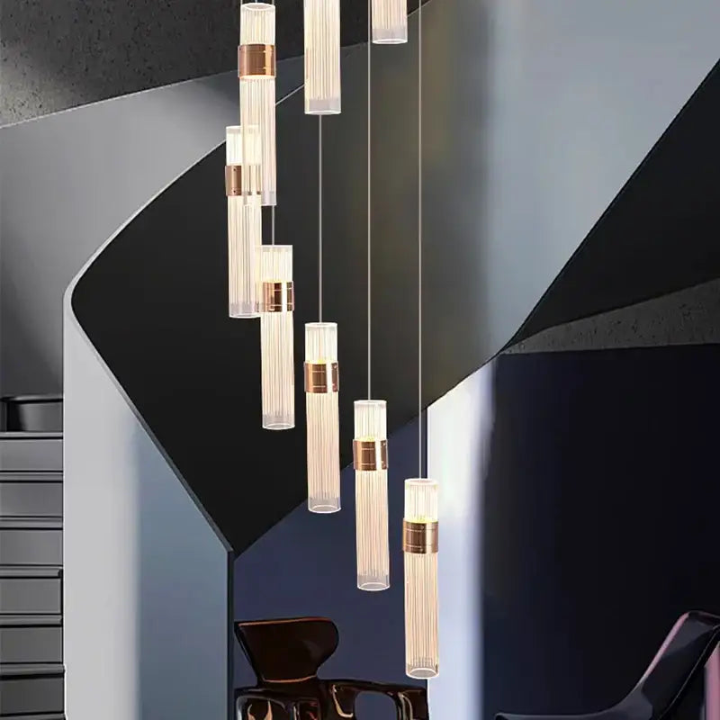 Modern gold pendant light with geometric design, translucent ribbed glass cylinders, brushed brass, adjustable height for dining room