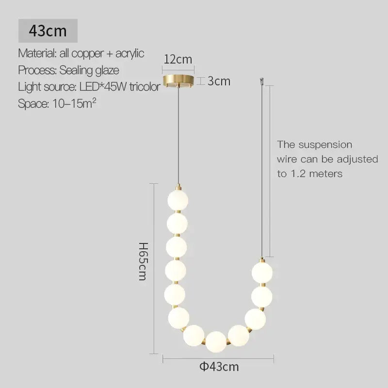A modern chandelier light fixture with frosted acrylic spheres and a brass finished copper mount for living room use