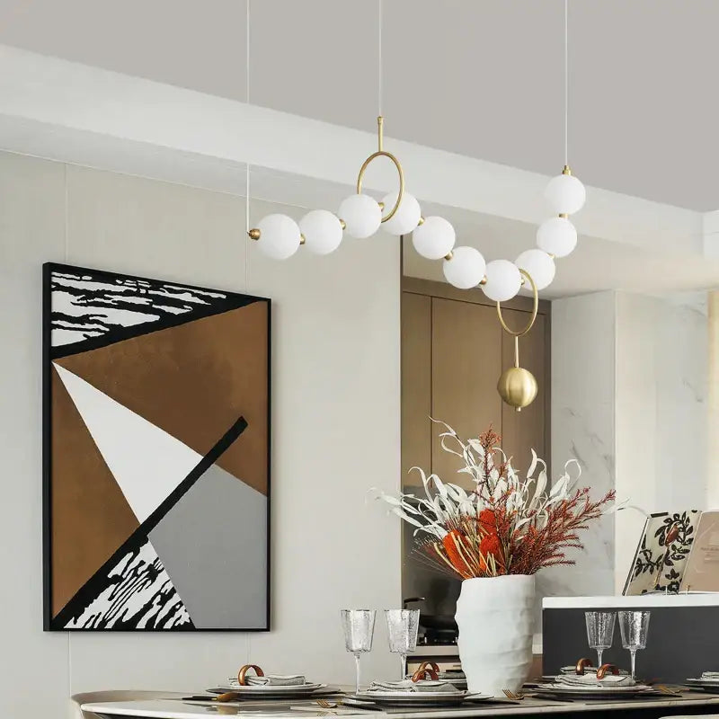Modern gold chandelier light fixture with white spherical bulbs and copper modern chandelier rings for living room use