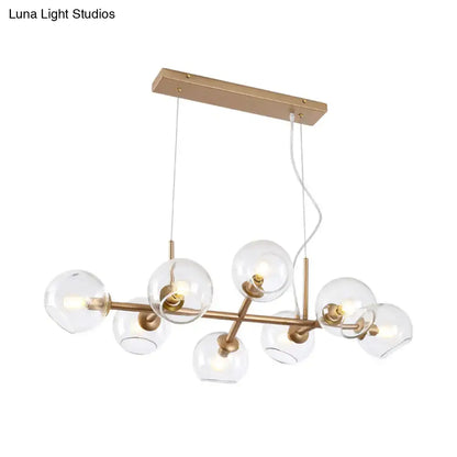 Modern gold brass chandelier with clear glass globe bulbs ideal for dining room lighting and decor