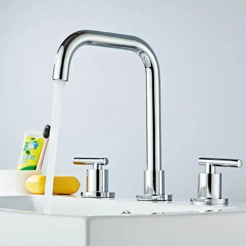 Modern gold and chrome brass basin faucet with chrome curved spout and two handles for hot and cold water use