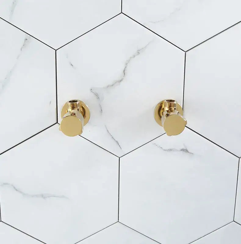 Modern gold and chrome brass triangle valve bathroom water control with gold finished brass triangle handles on white marble tiles