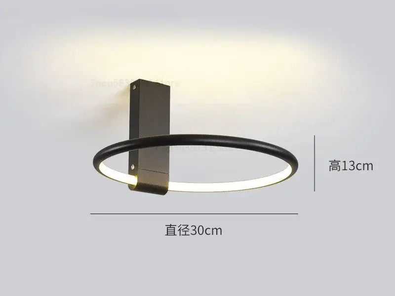 Modern black circular led wall sconce with illuminated ring complementing decorbites circular led ceiling light design
