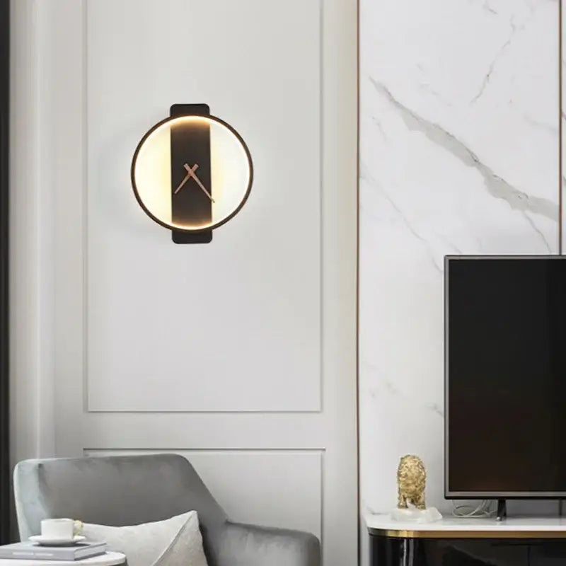 Modern gold circular led wall lamp wall clock with black frame warm glowing light and minimalist gold-toned hands