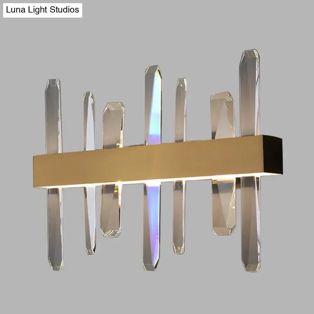 Modern gold wall sconce featuring a clear crystal bar design with faceted glass rods on a rectangular base