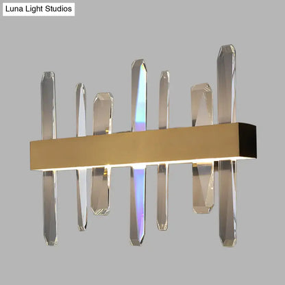 Modern gold wall sconce featuring a clear crystal bar design with faceted glass rods on a rectangular base
