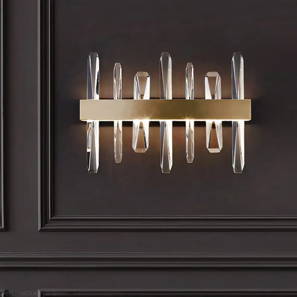 Modern gold wall sconce with clear crystal bar prisms designed for elegant bedroom lighting