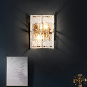 Modern gold wall sconce with four warm lights and clear water glass panels for elegant bedroom lighting