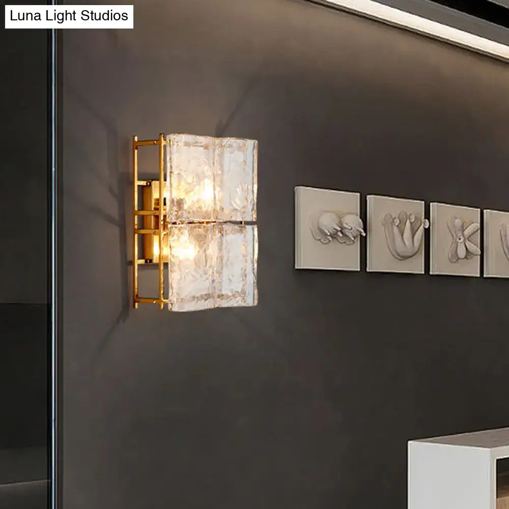 Modern gold two-light wall sconce with clear water glass textured shades for bedroom lighting