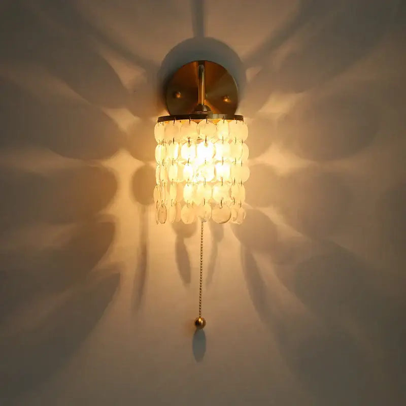 Modern gold conch shell wall light fixture with brass base and white shell discs for bedroom light fixture with pull chain switch