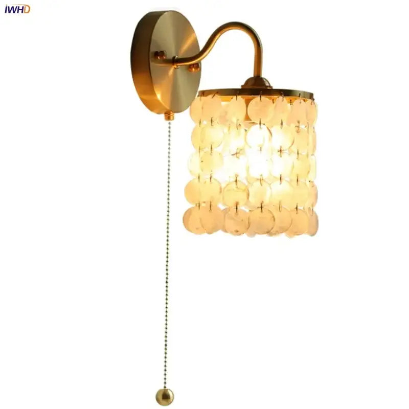 Modern gold conch shell wall light fixture with cylindrical shade of translucent circular shell discs and pull chain switch