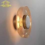 Modern gold wall lamp with decorbites cracked glass amber shade and circular frosted lens for bedroom lighting