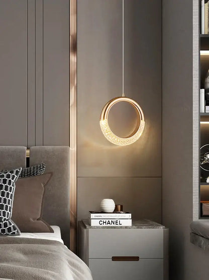 A modern gold crescent pendant light made of high-quality French metal with a textured surface for dining settings