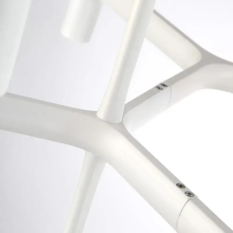 White plastic chair frame with sleek rounded joints paired with modern gold crown major chandelier decorbites crown major