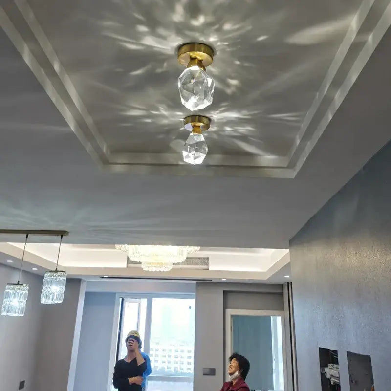 Modern gold crystal aisle ceiling light with two pendant lights casting geometric shadows in entryway decorbites crystal aisle