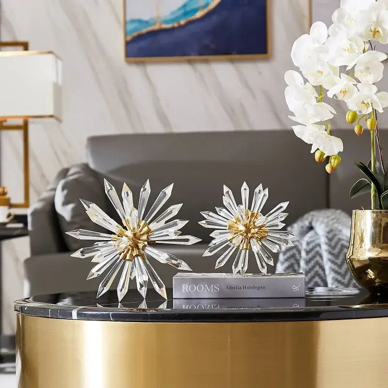 Two clear crystal ball acanthosphere ornaments with gold centers on a golden table for modern home decoration