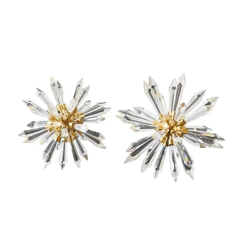 A pair of elegant gold-toned starburst earrings with clear crystal rays for refined home decoration decorbites crystal ball