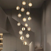 Modern gold crystal ball chandelier with multiple warm glowing glass orbs on a metallic frame for staircase lighting