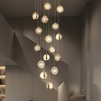 Modern gold crystal ball chandelier with multiple warm glowing glass orbs on a metallic frame for staircase lighting
